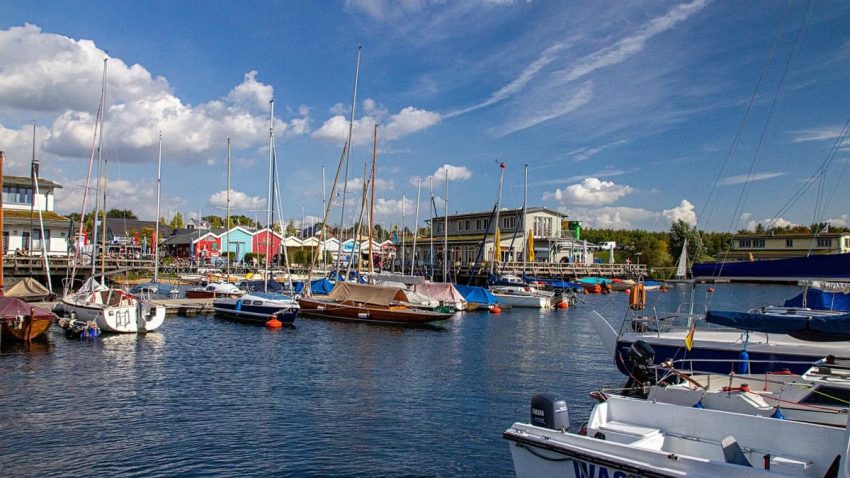 Captivating view of a vibrant marina with yachts in Leipzig, Germany under a bright blue sky.